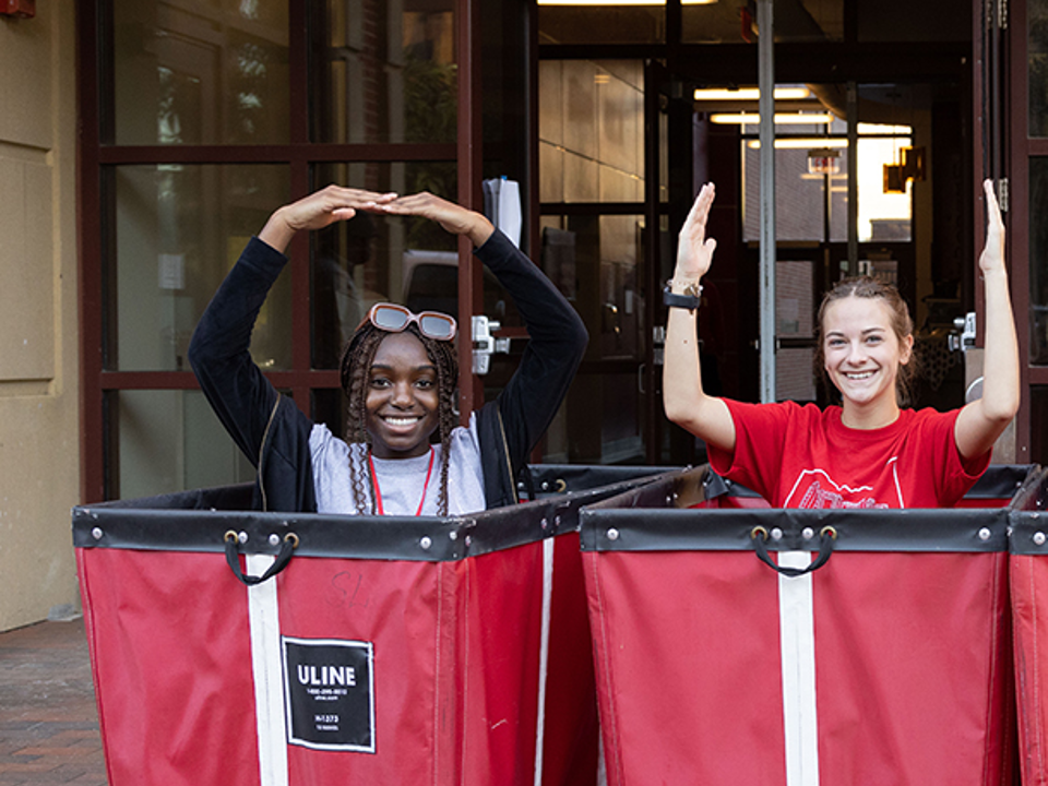 Tinu Ijewemen and Peyton Wurth in red bins spelling out O-H-I-O in front of Scott Hall