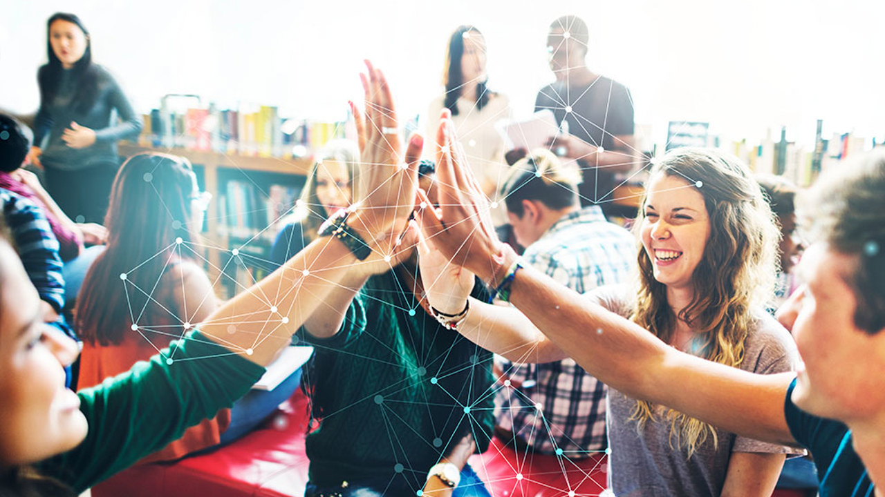 Students high-fiving each other in a classroom