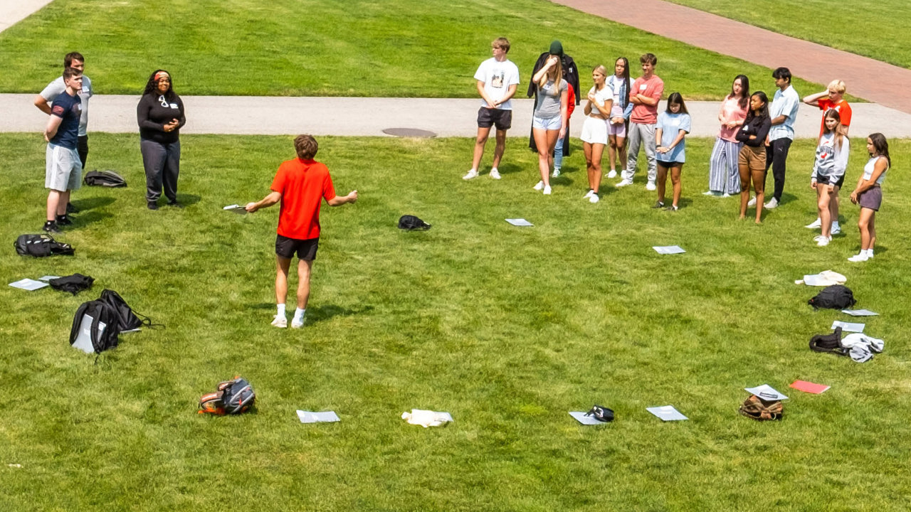 Students in a circle on the Oval during orientation